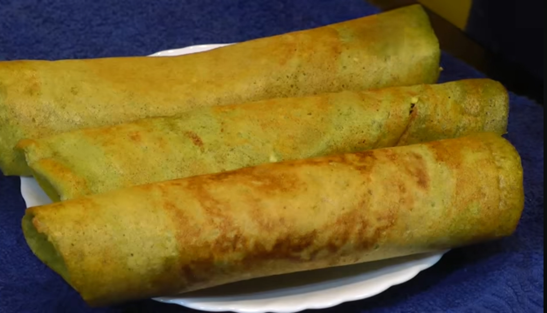 Three rolled green dosa on plate